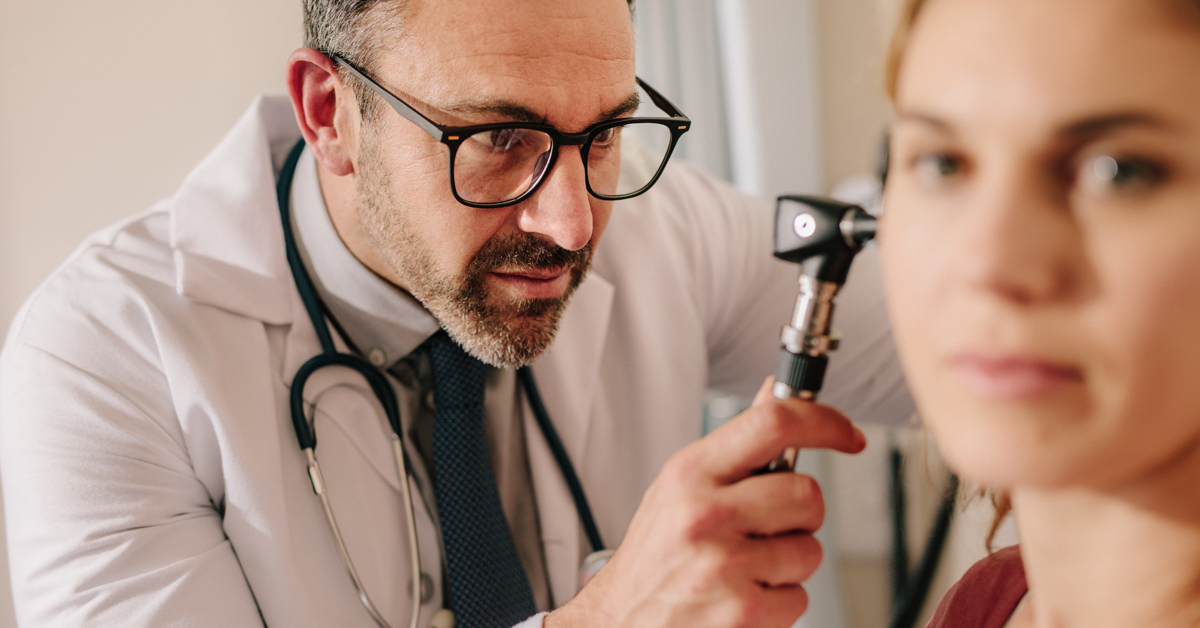 A physician uses an otoscope to examine the inside of a patient’s ear