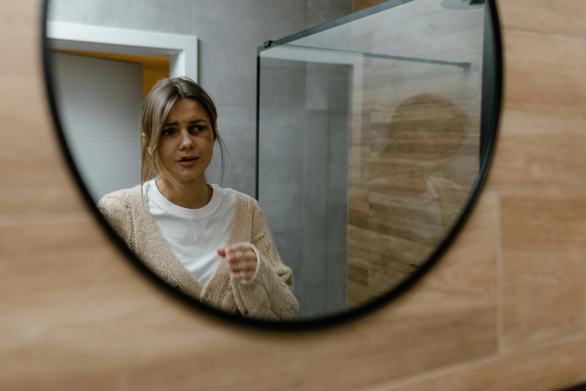 Woman with a black eye looking into the mirror