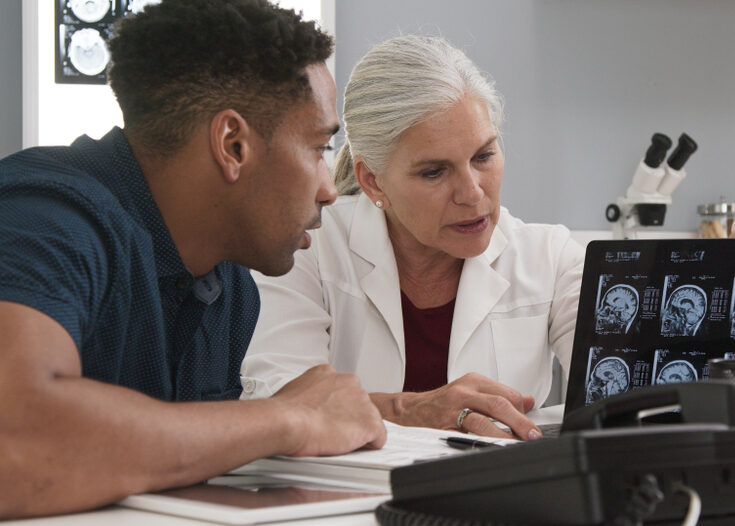 Researcher and student in a lab looking at brain tissue slides