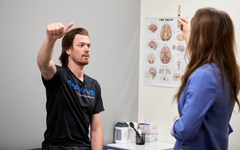 Former hockey player Tyler Brower goes through exercises with a physician at the doctor’s office