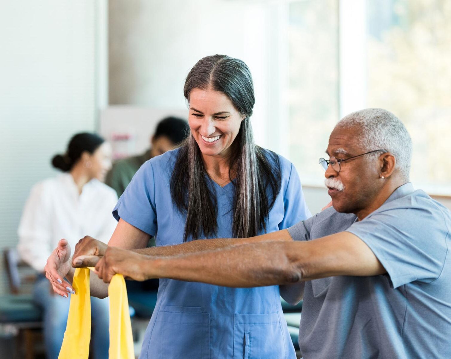 An occupational therapist helps a patient rehab his motor functions