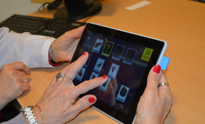 Researchers going through memory tests on a computer tablet