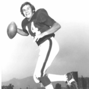Former NFL quarterback and Legacy Donor Bill Demory holds a football while posing in uniform