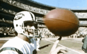 Former NFL quarterback and Legacy Donor Bill Demory spins a football on his finger