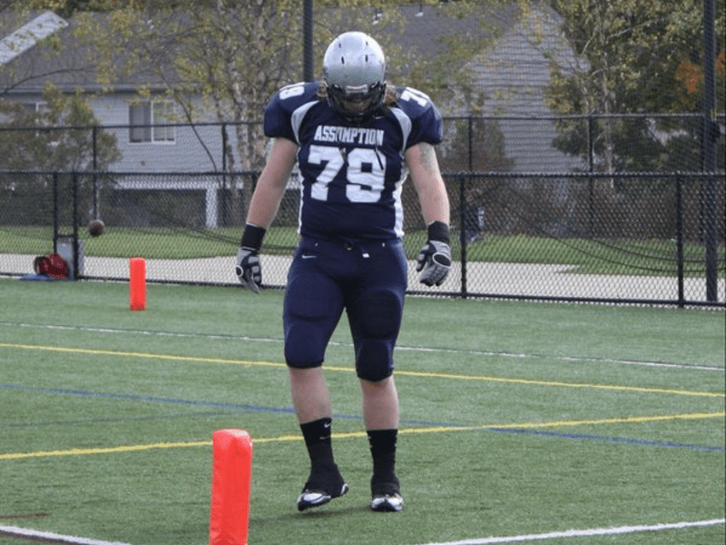 Assumption football player Matt Sidebottom in uniform on the football field.