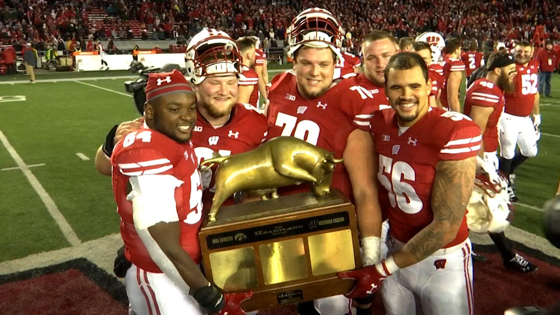 Wisconsin football player with arms raised on the field.