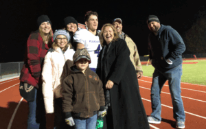 Legacy Donor Wyatt Bramwell and family on the football field after a game