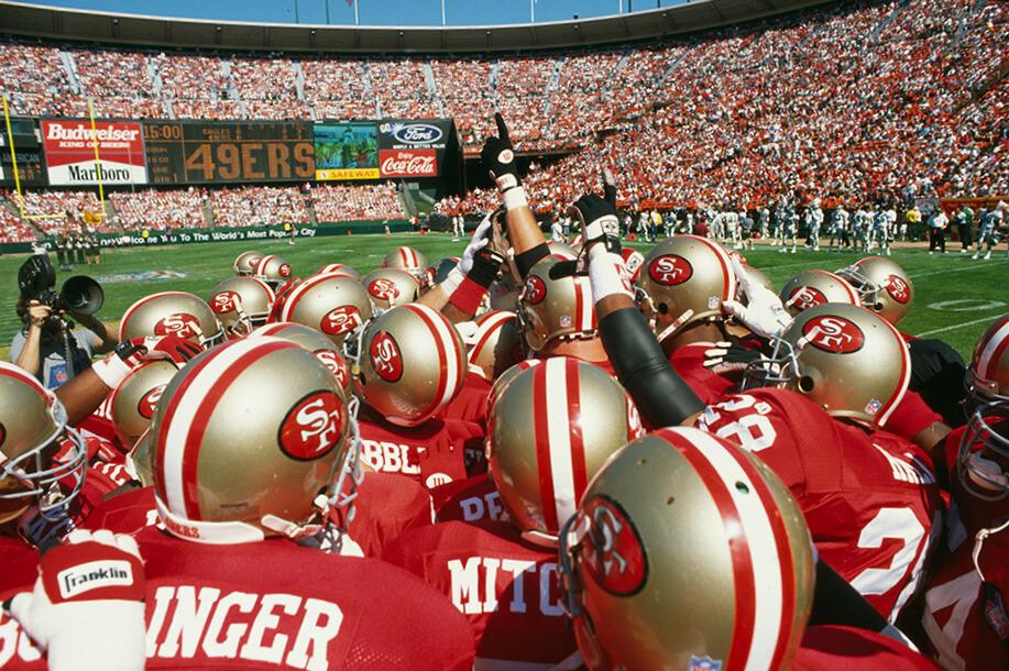 Members of the San Francisco 49ers in a huddle on the field
