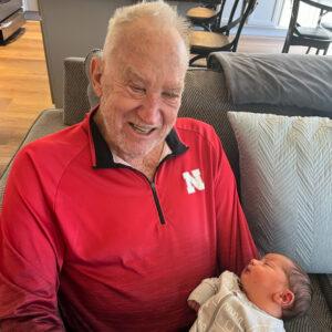 Legacy Donor and former college football player Jim Huge with his grandchild in lap