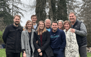Legacy Donor and former college football player Jim Huge with his family in the woods