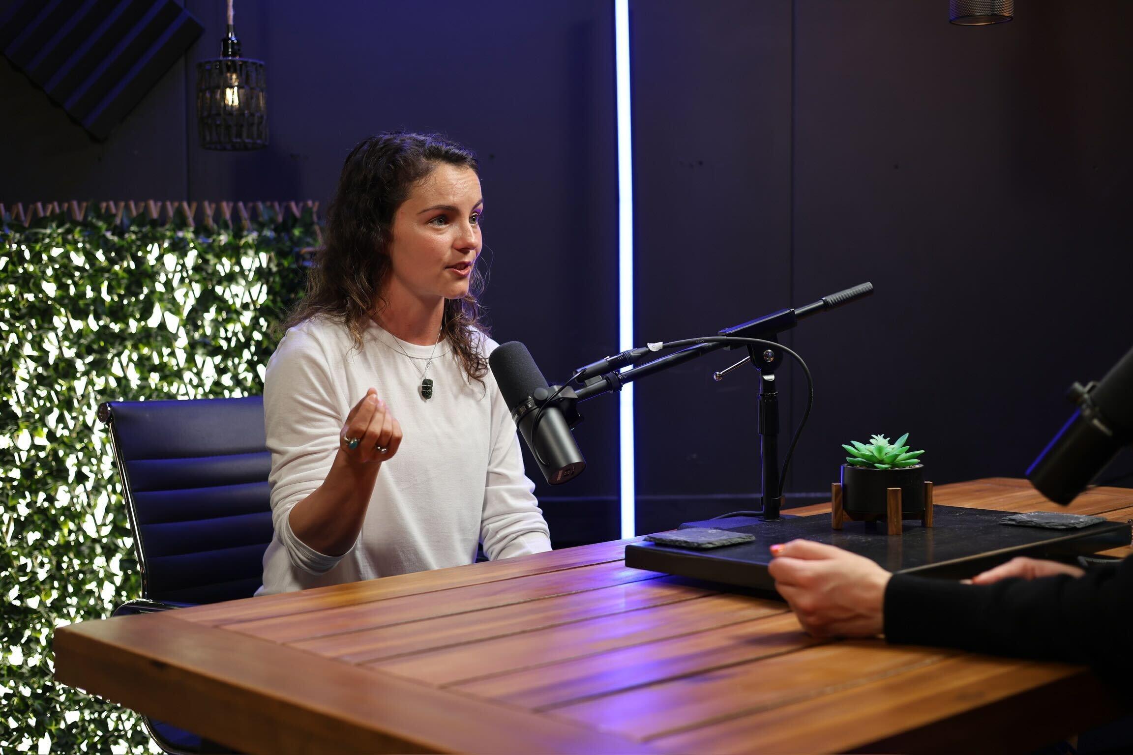 Hollywood stuntwoman Sydney Olson speaks in front of microphone for Invisible Impact podcast