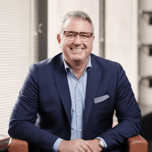 Concussion & CTE Foundation Board of Directors member Erik Smith smiles in a suit