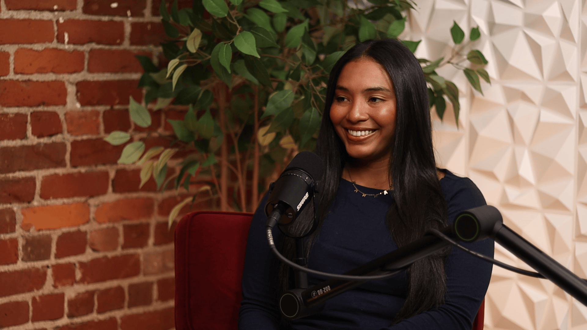 Former Division 1 soccer player Hannah Hall speaks in front of a microphone for the Invisible Impact podcast