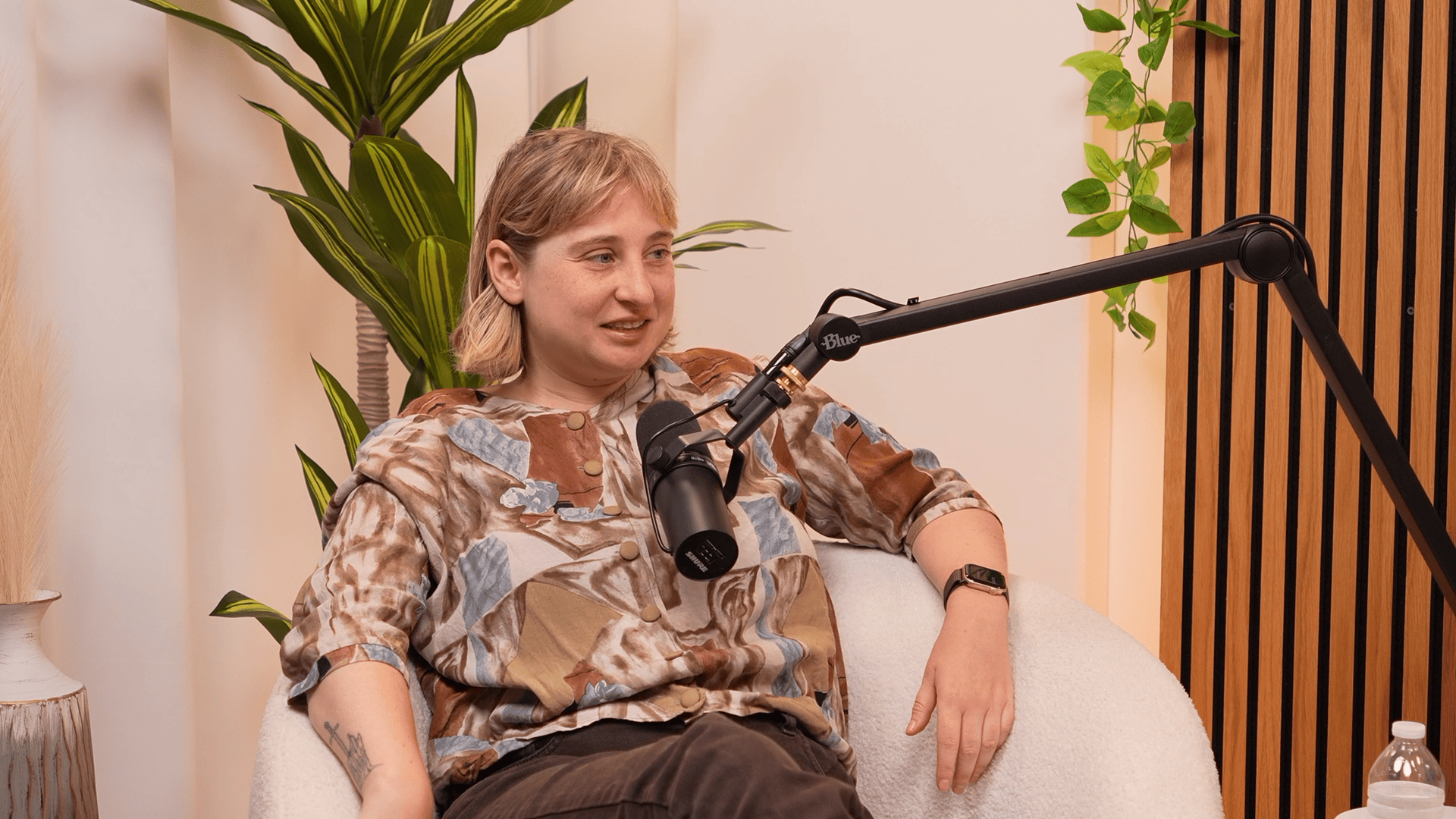 Architecture critic and writer Kate Wagner speaks in front of a microphone for the Invisible Impact podcast