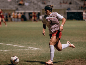 Former Chico State soccer player Caroline Souza dribbling the ball on field