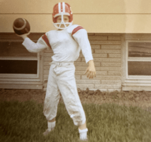 Jim Yost in his youth holding a football