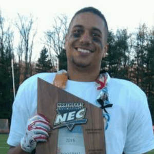 Former college football player Marcus Alston holds a NEC championship trophy