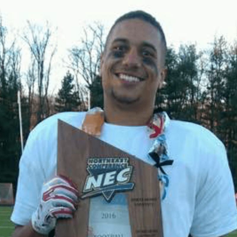 Former college football player Marcus Alston holds a NEC championship trophy